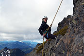 Rock climber rappelling off Castle Peak