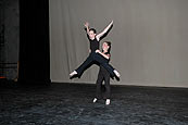 A partnered jump during dance recital.